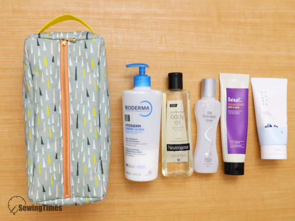 A flat lay view of the green quad-organizer bag next to five full-sized skincare and body lotion bottles, demonstrating its large storage capacity.