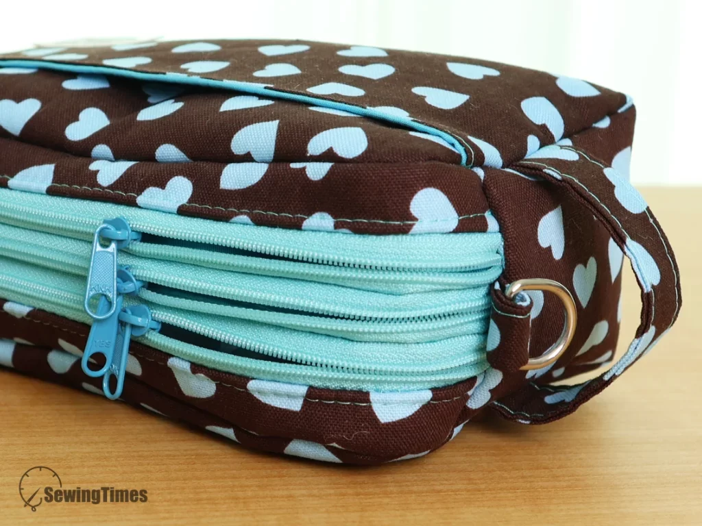 Close-up of the three high-quality mint blue zippers and side handle detail of the handmade crossbody bag.