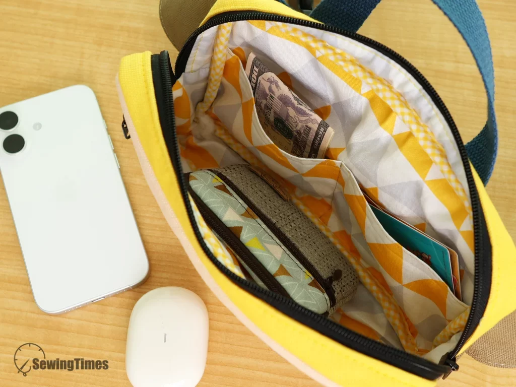 The open interior of the khaki sling bag revealing a patterned fabric lining and a functional inner pocket for organization.