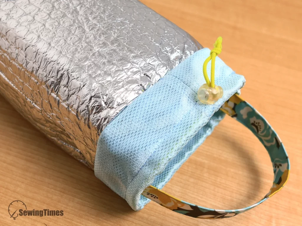 Inside-out view or detail shot showing the silver thermal foil insulation layer and light blue mesh drawstring top with a cord lock.