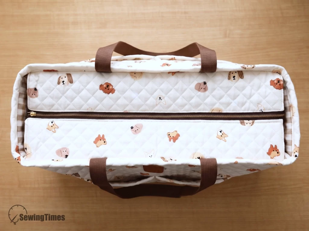 Top-down view of the closed recessed zipper panel on the quilted travel and diaper bag, demonstrating a clean, professional sewing finish.