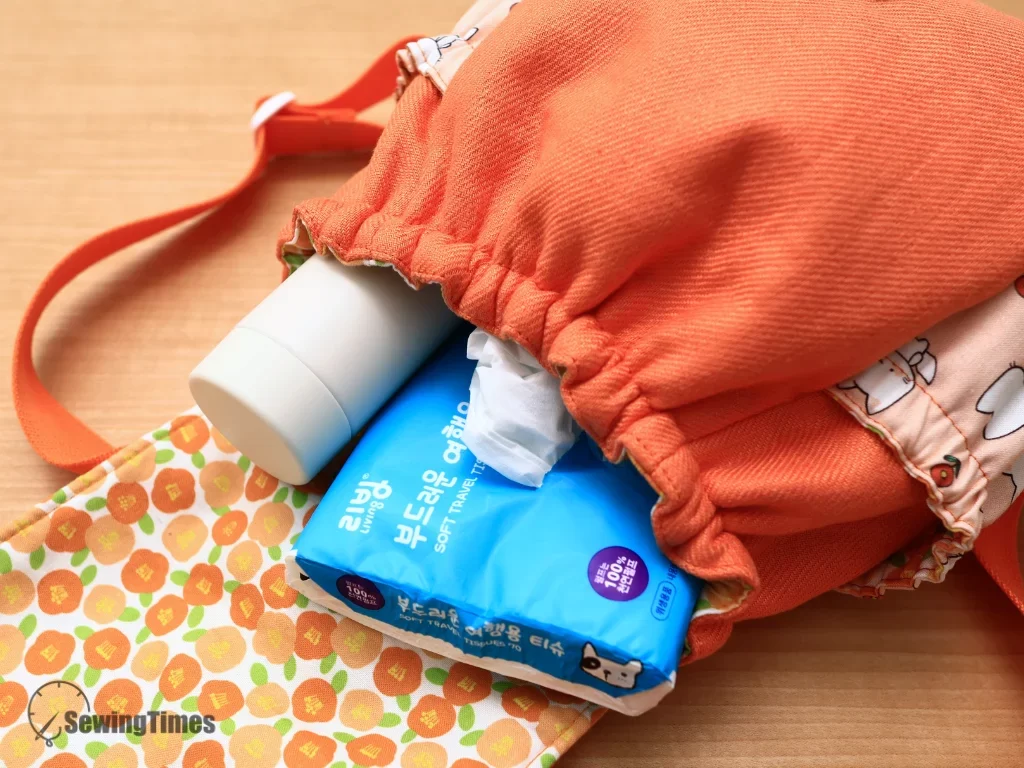 Open kids backpack packed with a water bottle and travel tissue pack showing storage capacity.