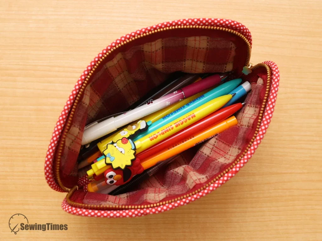 A top-down view of the wide-open pencil case filled with various colorful pens and highlighters, highlighting its large storage capacity.