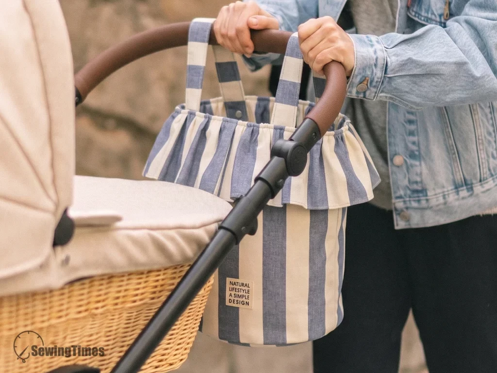 Full view of a handmade stroller bucket bag with ruffles hanging on a stroller bar.