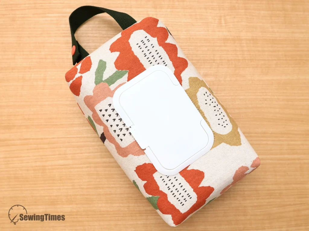 Compact floral pattern baby wipes bag with a snap strap, suitable for stroller attachment.